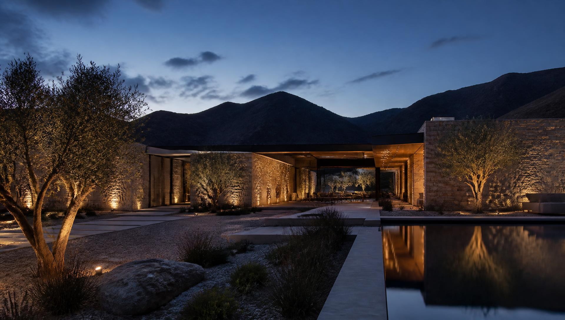 Modern stone desert villa at blue hour with reflecting pool